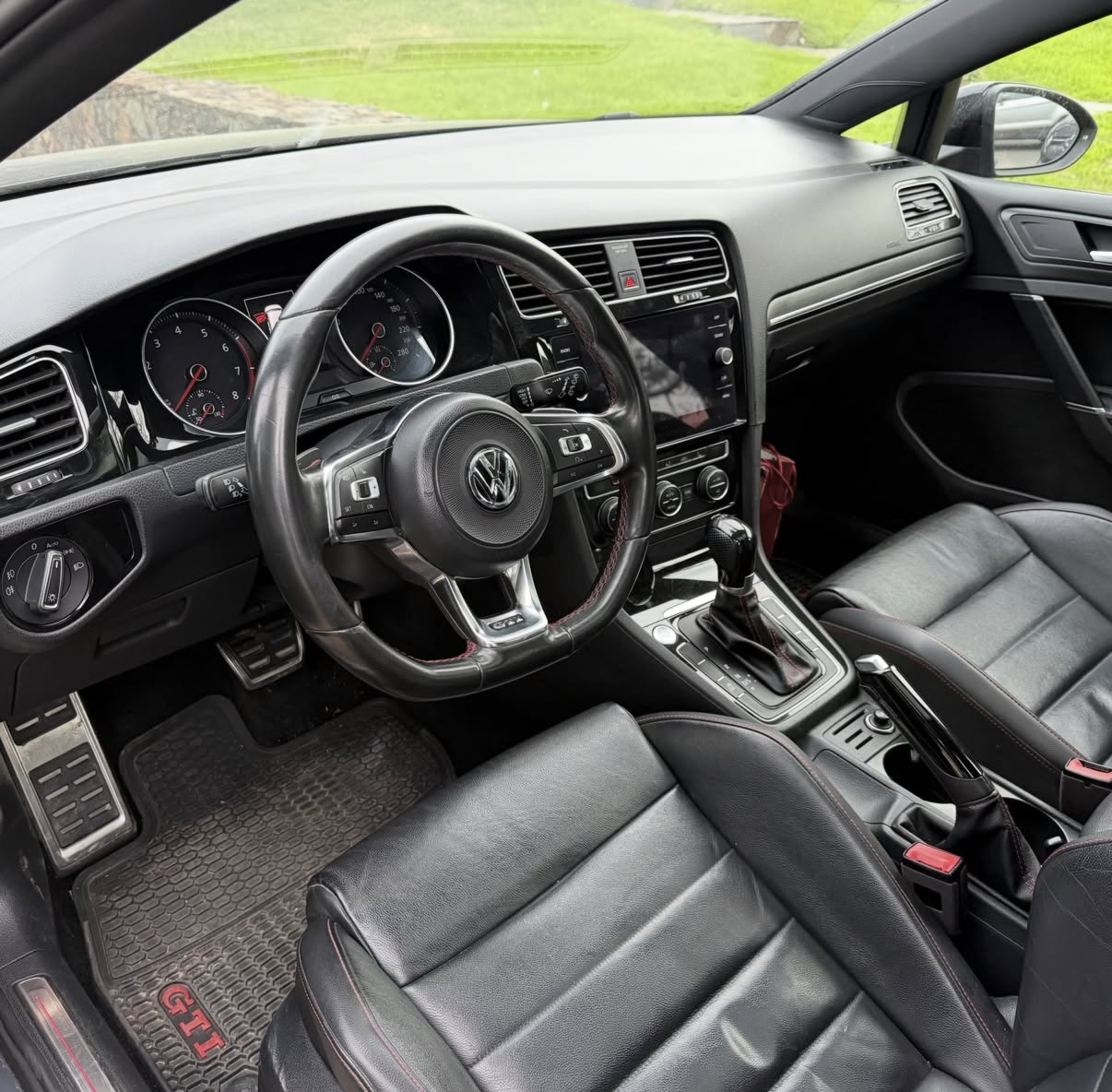 Interior de un Volkswagen GTI con costuras rojas y acabados premium